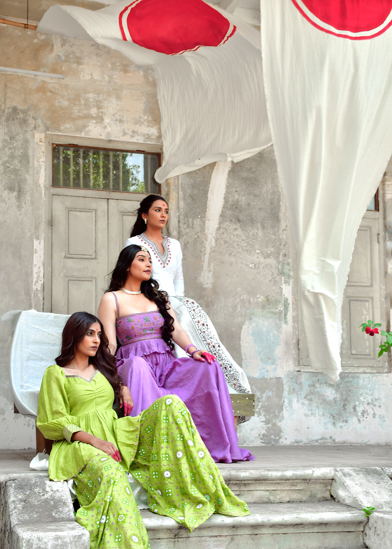 Group portrait of models in traditional wear in a courtyard